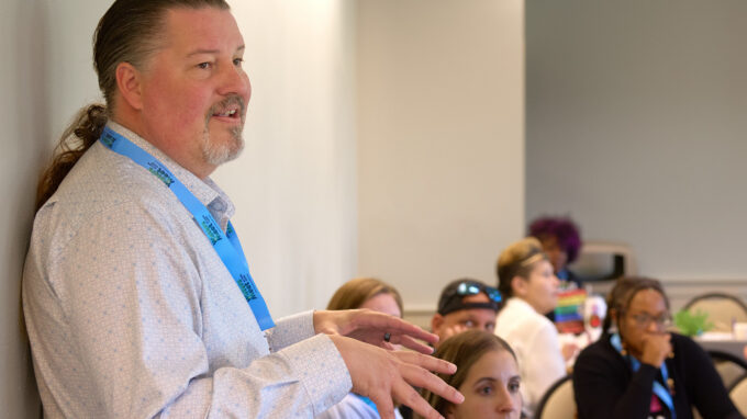 Photo of Zeke Smith speaking to a room of people.